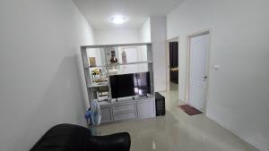 a living room with a flat screen tv on a entertainment center at Joyful House Naiyang beach in Thalang