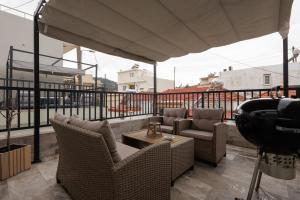 a balcony with wicker chairs and a table at Hidden Petra Luxury Suites 2 in Ialysos