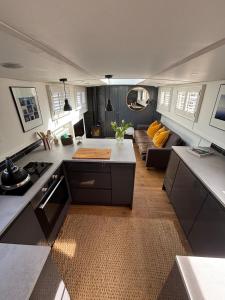 a kitchen and living room with a couch at Unique 2 Bed Waterside Retreat Pet Friendly in Upton upon Severn