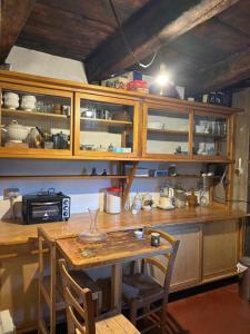 a kitchen with wooden cabinets and a table with chairs at Via del Campo 98 in Castione Andevenno