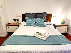 a bed with two towels and two pillows on it at Casa cubo in Alhama de Granada