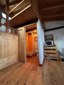 a room with a wooden floor and a room with a desk at Via del Campo 98 in Castione Andevenno +23 photos