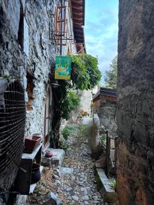 an alley in an old building with a sign on it at Via del Campo 98 in Castione Andevenno