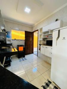 a kitchen with a refrigerator and a counter top at Casa Amarela de Praia in Maricá