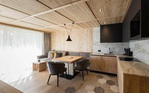 a kitchen and dining room with a table and chairs at Miraval NaturHotel in Badia