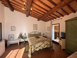 a bedroom with a bed and a wooden ceiling at B&B Il Fienile San Gimignano in San Gimignano