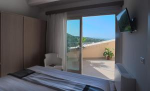 een slaapkamer met een bed en een glazen schuifdeur bij Casa Majore in Chiaramonte Gulfi