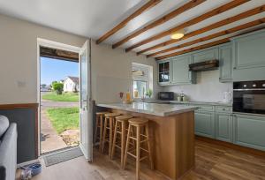 a kitchen with green cabinets and a counter top at Landscove Chalet 19 in Brixham