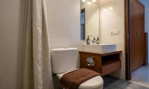 a bathroom with a toilet and a sink and a mirror at Cening Ayu Sanur in Sanur