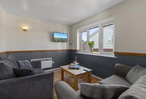 a living room with two couches and a table at Landscove Chalet 19 in Brixham