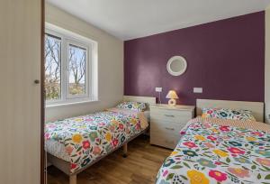 a bedroom with two beds and a window at Landscove Chalet 19 in Brixham