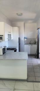 a kitchen with white cabinets and a white counter top at 15 on 11th Summerstrand in Summerstrand