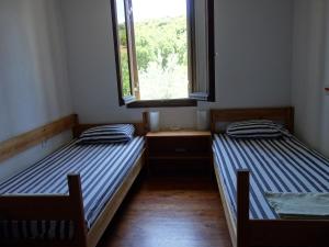 twee bedden in een kamer met een raam bij Traditional Stonehouse in Potistika