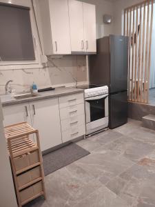 eine Küche mit weißen Schränken und einem schwarzen Kühlschrank in der Unterkunft Studio Ariadne in Thérmi + 12 Fotos