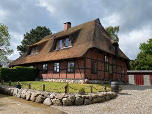 a large house with a thatched roof at Dannauer Reetkate - Wiesenblick in Oldenburg in Holstein