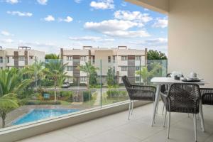 a balcony with a table and chairs and a view of a building at Penthouse Kyo - Private Rooftop & Jacuzzi in Grand-Baie
