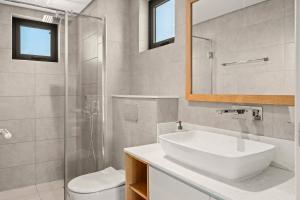 a bathroom with a sink and a toilet and a mirror at Penthouse Kyo - Private Rooftop & Jacuzzi in Grand-Baie