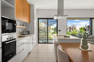 a kitchen with white appliances and a large window at Penthouse Kyo - Private Rooftop & Jacuzzi in Grand-Baie