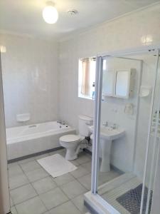 a bathroom with a tub and a toilet and a sink at 15 on 11th Summerstrand in Summerstrand +10 photos