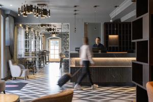 Eine Frau geht mit einem Mann durch die Lobby eines Hotels. in der Unterkunft Bastion Heritage Hotel in Zadar
