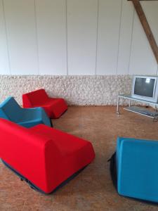 a room with four red and blue chairs and a tv at Les Renaudières Chalais in Chalais