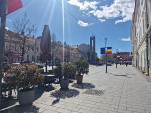a city street with a table and a umbrella at Eroilor Downtown Studio in Cluj-Napoca +11 photos