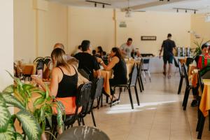 a group of people sitting at tables in a restaurant at Hotel Temu in Villa Carlos Paz +50 photos