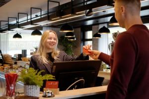a woman sitting at a counter talking to a man at Tailormade Hotel RIGIBLICK Küssnacht in Küssnacht