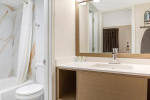 a bathroom with a sink and a toilet and a mirror at Quality Inn Findlay in Findlay +31 photos