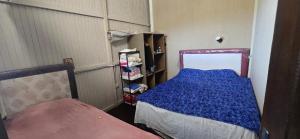 a bedroom with a bed with a blue blanket at Cabaña con piscina y vista al lago in San Bernardino