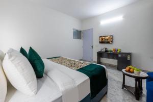 a bedroom with a large bed and a table at Yashobhoomi Suites near Yashobhoomi Convention Centre in New Delhi