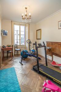 a room with a gym with a treadmill and a fireplace at Hôtel Restaurant Continental in Évian-les-Bains