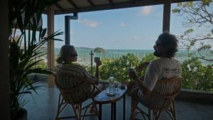 two people sitting at a table looking out a window at Surf's Up LOFT in Weligama