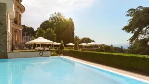 a large blue swimming pool next to a building at Villa Rothschild, Autograph Collection in Königstein im Taunus