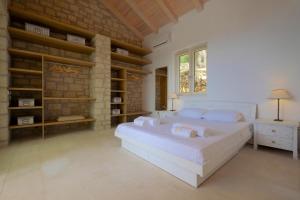 a bedroom with a large bed and a brick wall at Erimitis View Villa in Magaziá +9 photos