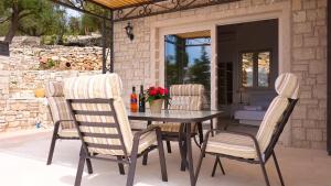 a table and four chairs on a patio at Erimitis View Villa in Magaziá