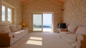 a living room with two couches and a television at Erimitis View Villa in Magaziá