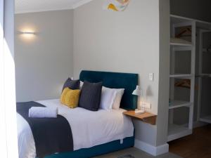 a bedroom with a bed with a blue headboard at Lagoon View Cottage in Knysna