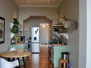 a kitchen with a white refrigerator and a table at Lagoon View Cottage in Knysna