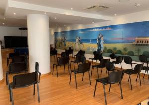 a room with chairs and a large painting on the wall at Hotel Luxor in Rimini