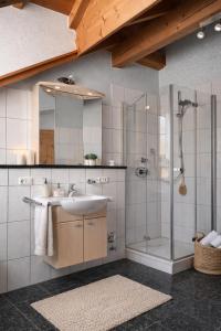 a bathroom with a sink and a shower at Helle Ferienwohnung im Bayerischen Wald mit Balkon, Garten & viel Platz für 4 in Mauth +8 photos