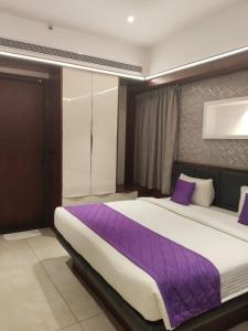 a bedroom with a large bed with purple sheets at SRS Suites in Bangalore +22 photos