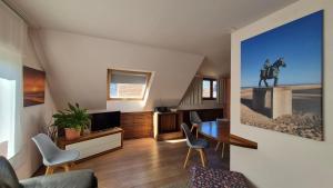 a living room with a table and a horse picture on the wall at Oostduinkerke Apartments in Oostduinkerke