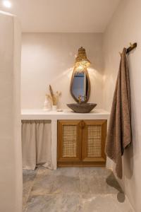 a bathroom with a sink and a mirror at Cavo Dio 1 - Beachfront bliss - Cozy Apt Pool Sunset in Káto Dhiminión +24 photos