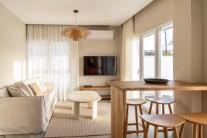 a living room with a couch and a table at Cavo Dio 1 - Beachfront bliss - Cozy Apt Pool Sunset in Káto Dhiminión