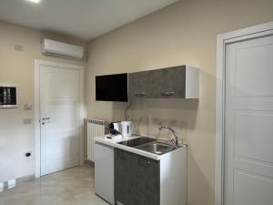a small kitchen with a sink and a microwave at Rafinù B&B in Ercolano