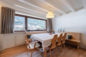 a dining room with a table and chairs and a window at Cesa del Volp in Canazei