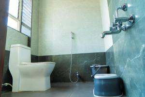 a bathroom with a toilet and a shower at Jageshwari Executive in Kolhapur