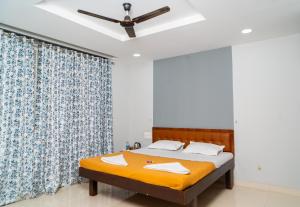a bedroom with a bed and a ceiling fan at Jageshwari Executive in Kolhapur