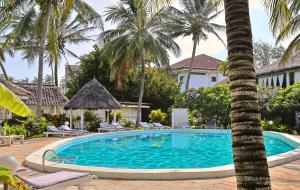 a pool at a resort with palm trees at Ascot Watamu Resort in Watamu